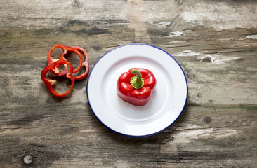 Fresh red pepper cut and placed on a plate on a rustic table