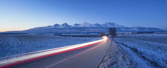 Foto auf Acrylglas night cars lights on the road in winter morning © sergejson