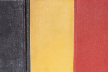 three colored background (black, yellow and red) made from three old hardcovers of books, selective focus, belgium flag