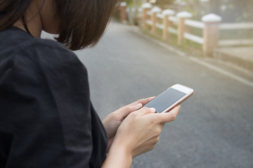 Woman holding smartphone on street