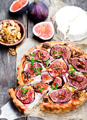 Delicious  tart with fresh figs and goat cheese on rustic wooden