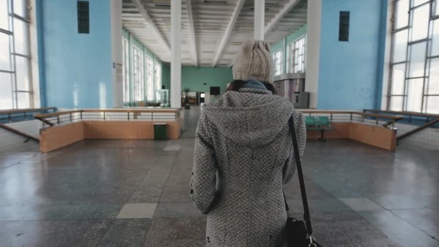 Woman walking alone in old railway station