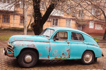 Old abandoned rusty blue car