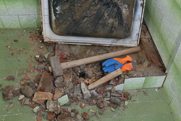 Home renovation, old bathtub and tiles demolishing in bathroom