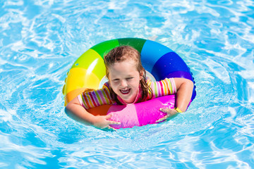 Little girl with toy ring in swimming pool