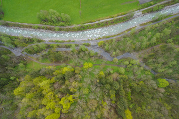 forest, fast river and green grass from the sky