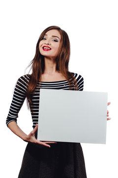 Long-haired beautiful cute brunette woman holding a rectangular blank-poster. white canvas with space for text.Red lips