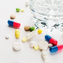 Medicine. Colored pills with the glass of water. Square