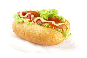Hotdog with ingredients on serviette on white background