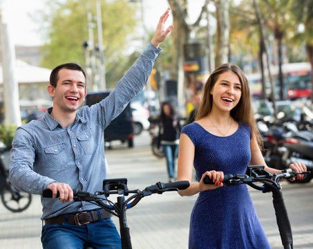 Happy young man and woman with electrkc bikes