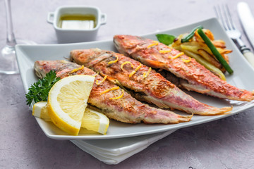 Grilled red mullets on square plate selective focus  front