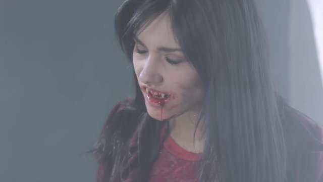 Happy female vampire killing man closeup