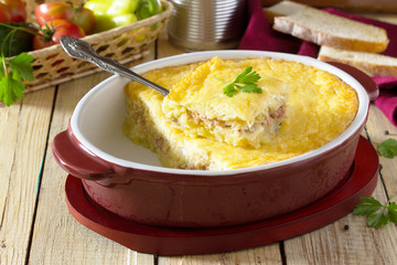 Baked potatoes with meat and cheese on the table in a rustic sty