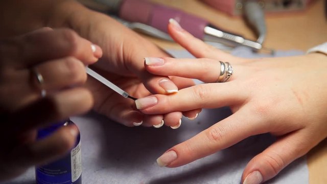 Manicurist prepares woman's nails for paint, woman comes to the manicure salon, nail care, business in beauty