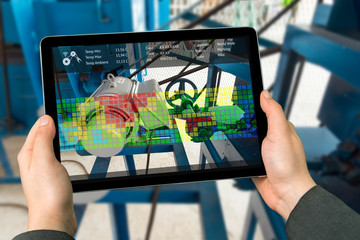 Industry 4.0 concept .Man hand holding tablet with Augmented reality screen software for measure...