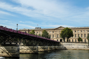 Fototapeta premium Pont des Arts across the Seine river, Louvre musum in Paris