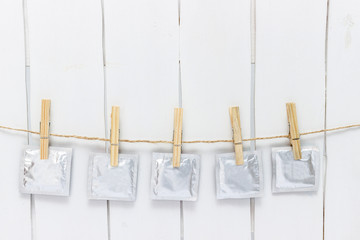 close up of a condom and  clothes peg on white background with clipping path