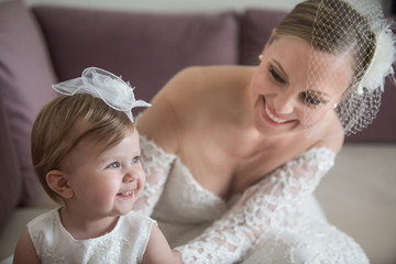 Beautiful bride with her little daughter. Summer wedding and baptism. Cute baby girl with her bride...