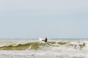 A young man surfing a wave on the shores of Mar del Plata, Argentina