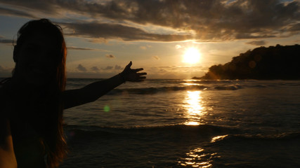 Naklejka na ściany i meble Brazilian Woman enjoying a sunset on the Beach