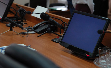 Press media conference studio with monitors, microphones on wooden table