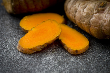 turmeric slices close up on gray background