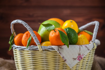 citrus fruits in a wicker basket on a wooden background