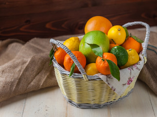citrus fruits in a wicker basket on a wooden background
