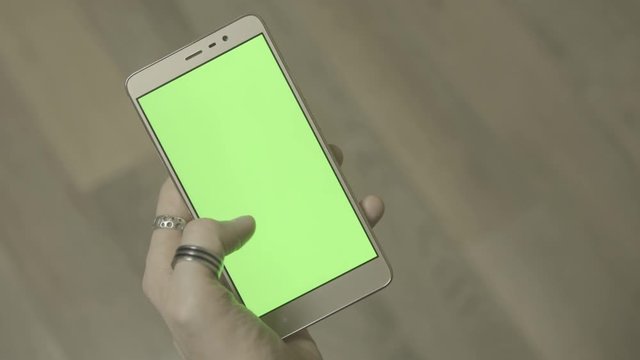 Man using smartphone with green screen. Close up shot hands with mobile, 4k ungraded footage shot in 24fps 