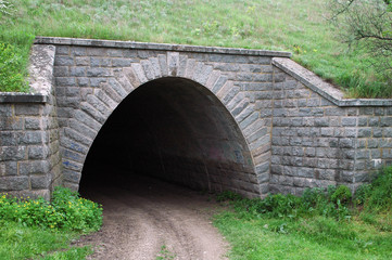 Fototapeta na wymiar Old stone tunnel in dark with light