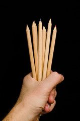 Hand holding wooden color pencils