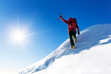 Gardinen Extremer Wintersport: Kletterer erreicht den Gipfel eines schneebedeckten Gipfels in den Alpen. Konzepte: Entschlossenheit, Erfolg, Stärke. © rcaucino