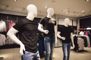 Men's clothing store. Three mannequin dressed in black t-shirts in clothing store