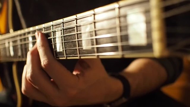 Hand touching the guitar