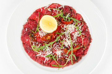 Carpaccio on a plate on a white background,top view closeup
