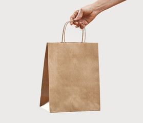 Woman holding paper shopping bag on gray background