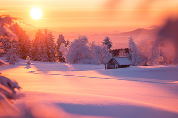 Wunderschöner Sonnenaufgang an einem kalten Wintertag im Erzgebirge mit einer kleinen Holzhütte...