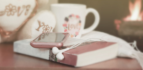 a smart phone on book with a cup of coffee and teddy bear on woo