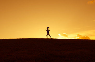 Silhouette of woman running cross country. 