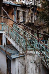 Fototapeta na wymiar Old blue rusty stairs in the ruined house.