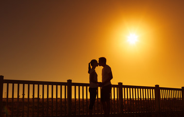 Couple kissing at sunset. 