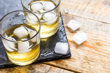 glass of whiskey on wooden background