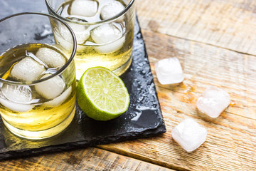 glass of whiskey on wooden background