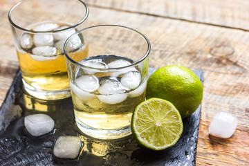 glass of whiskey on wooden background