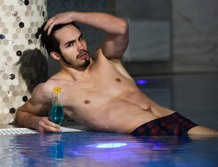 Handsome man lies near pool
