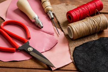 leather craft instruments on wooden background close up