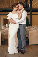 Fototapeta premium Beautiful and charming bride and handsome groom standing together on the terrace