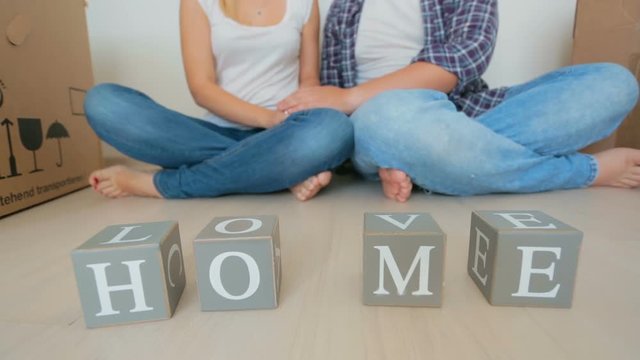 Closeup shot of young family making words Home and love on toy wooden blocks