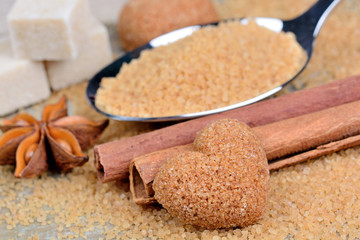 Beige sugar in a spoon and anise with cinnamon