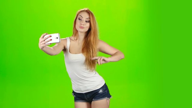 Selfie photos on mobile phone, poses redhead girl model. Studio